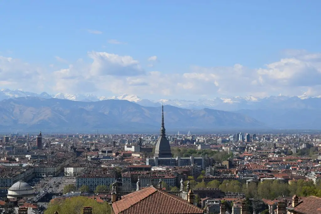 Stunning view of Turin cityscape with the Mole Antonelliana and Italian Alps in the distance.